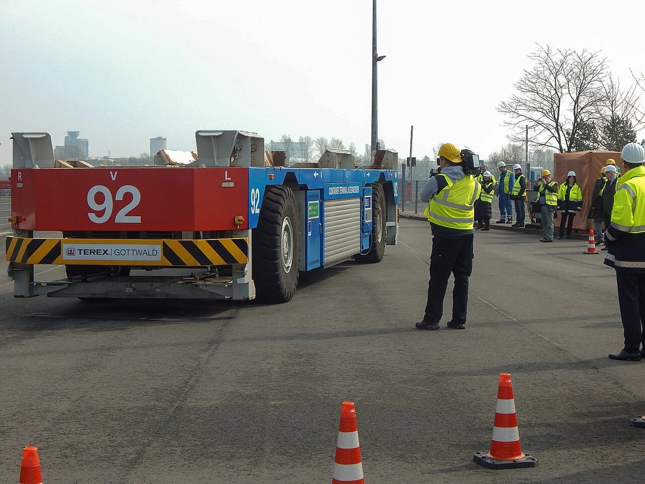 People standing beside an automated container vehicle