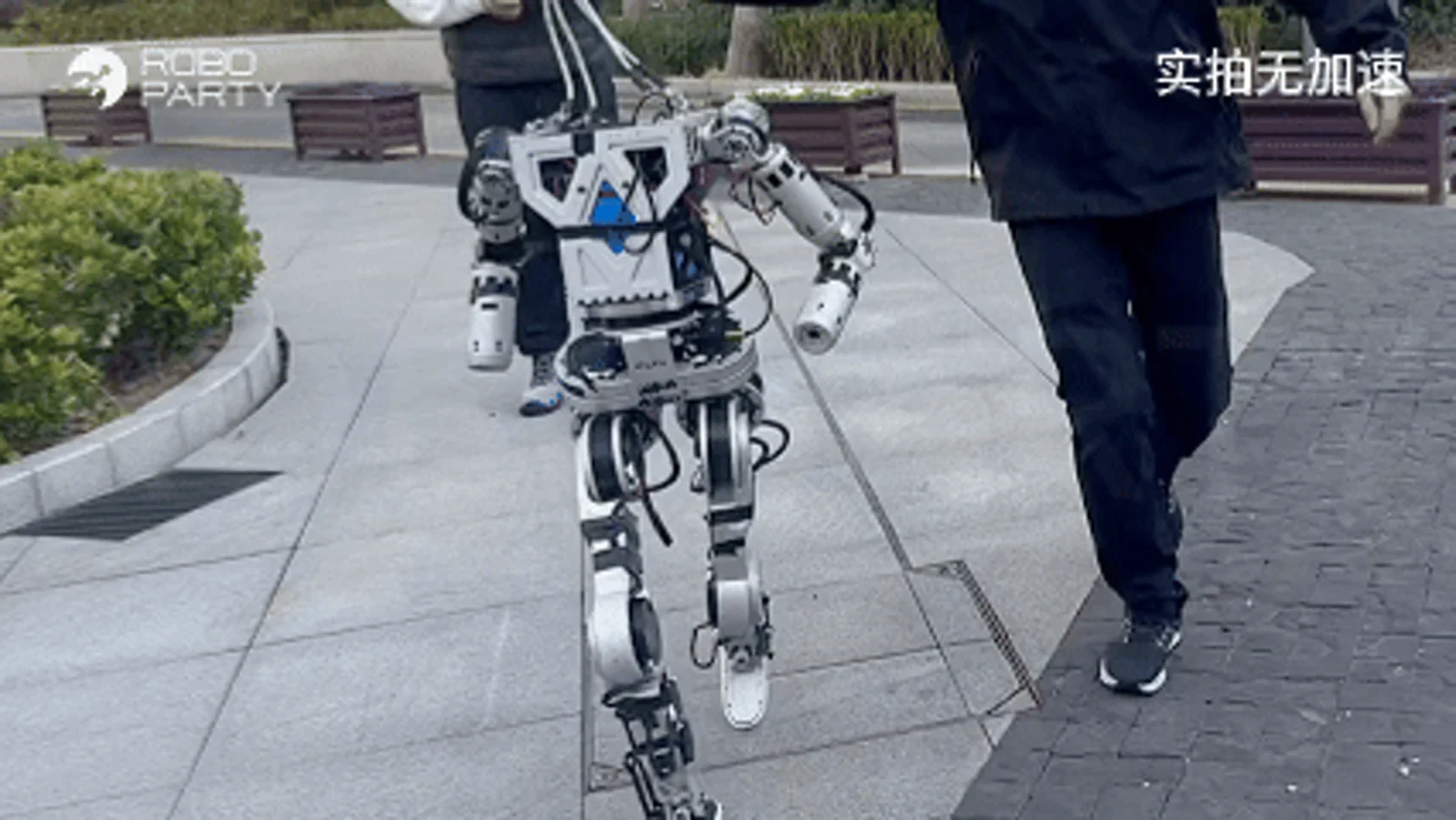 A robot walking outdoors in RoboParty's ROBOTO ORIGIN demonstration